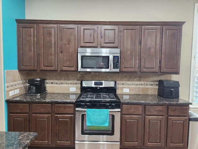 kitchen with dark brown cabinetry, decorative backsplash, appliances with stainless steel finishes, and dark stone counters