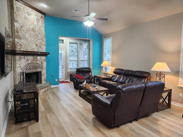 living room featuring a ceiling fan, wood finished floors, a fireplace, baseboards, and vaulted ceiling