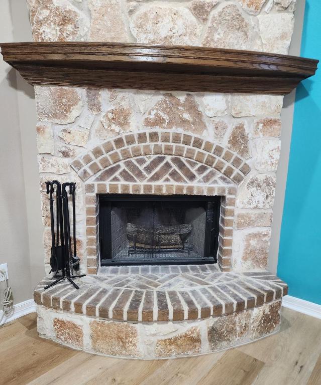 interior details with a fireplace with raised hearth, baseboards, and wood finished floors