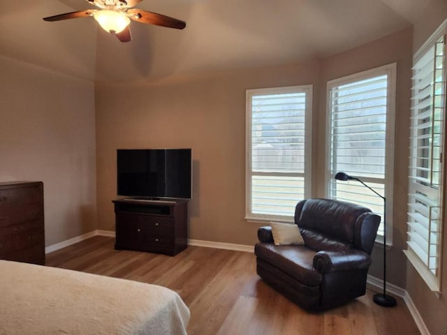 bedroom with a ceiling fan, wood finished floors, and baseboards