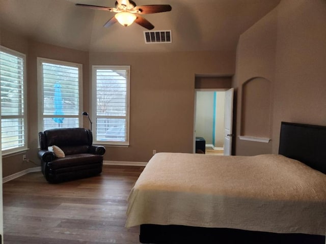 bedroom with visible vents, baseboards, wood finished floors, and vaulted ceiling