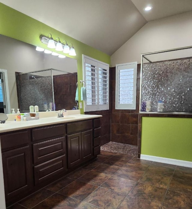 bathroom featuring walk in shower, vanity, and vaulted ceiling