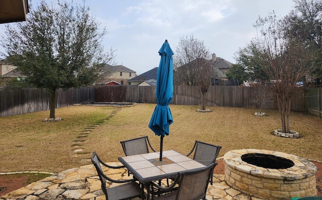 view of patio / terrace featuring outdoor dining area, a fenced backyard, and an outdoor fire pit