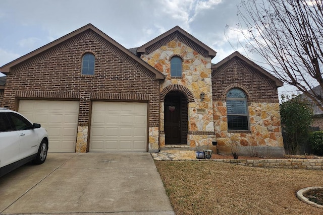 view of front of house featuring brick siding, stone siding, driveway, and a garage