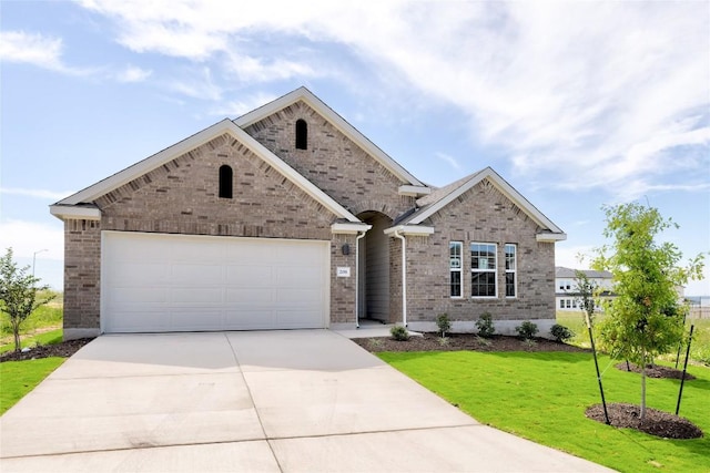208 Seattle Slew Dr, Jarrell, TX 76537 - view of front of house featuring brick siding, driveway, a front yard, and an attached garage