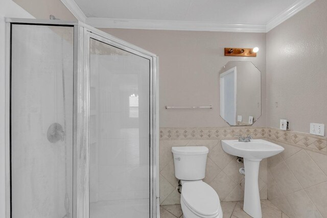 15009 Mossycup Ln, Austin, TX 78724 - bathroom featuring toilet, ornamental molding, a stall shower, a wainscoted wall, and tile walls