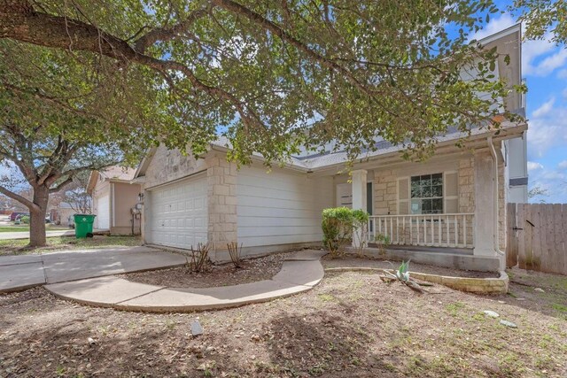 15009 Mossycup Ln, Austin, TX 78724 - view of front of property featuring a porch, a garage, driveway, and stone siding