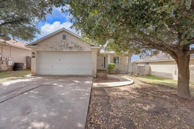 ranch-style house with driveway, fence, a garage, and stone siding