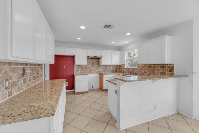 15009 Mossycup Ln, Austin, TX 78724 - kitchen featuring a peninsula, a sink, light tile patterned floors, light stone counters, and backsplash