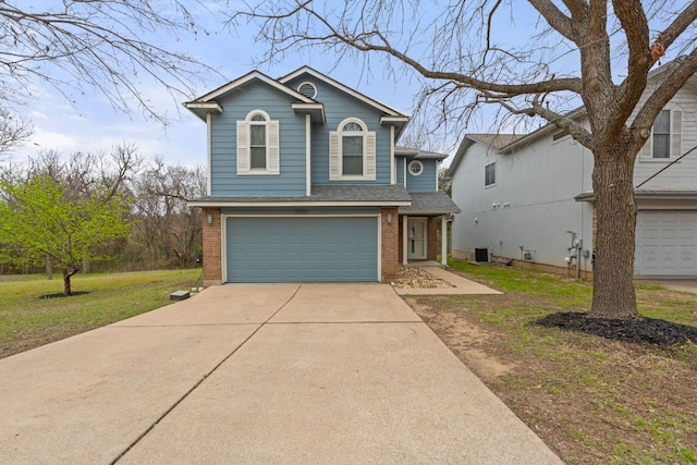 traditional home featuring brick siding, concrete driveway, central AC, a front yard, and an attached garage