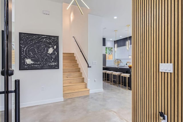 stairs featuring concrete floors, recessed lighting, and baseboards