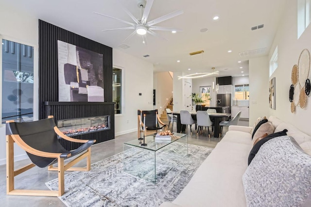 living room with recessed lighting, visible vents, stairway, finished concrete floors, and a multi sided fireplace