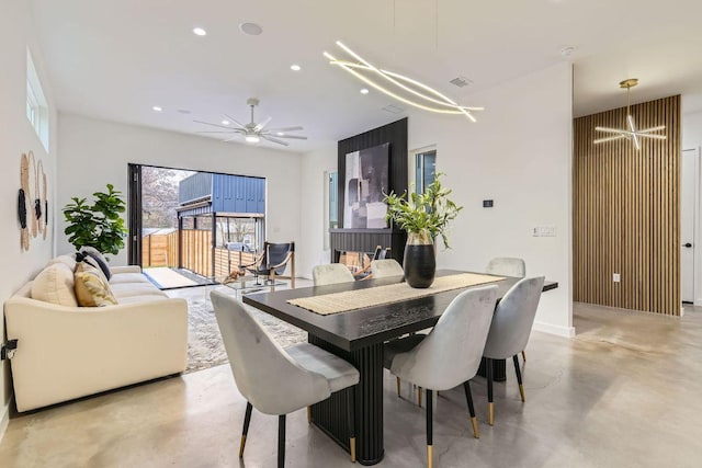 dining area with ceiling fan with notable chandelier, concrete flooring, and recessed lighting