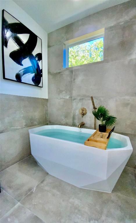 full bathroom featuring a freestanding tub and tile walls