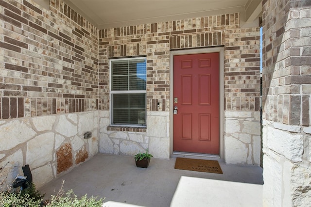 187 Dorchester Dr, Kyle, TX 78640 - view of exterior entry featuring covered porch, brick siding, and stone siding