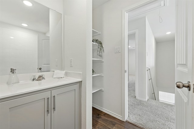 bathroom featuring baseboards, visible vents, wood finished floors, vanity, and recessed lighting