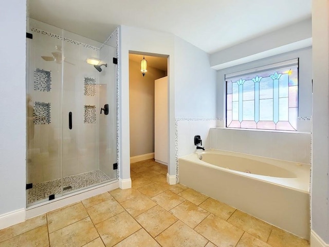 full bath featuring a garden tub, a shower stall, and baseboards