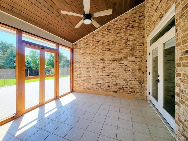 unfurnished sunroom with a ceiling fan, wood ceiling, and vaulted ceiling