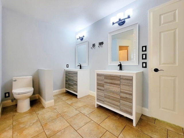 bathroom with toilet, tile patterned floors, baseboards, and vanity