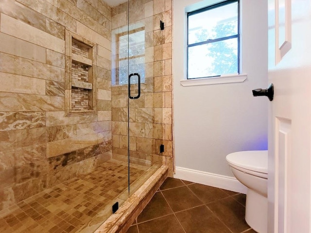 bathroom with baseboards, a shower stall, toilet, and tile patterned floors