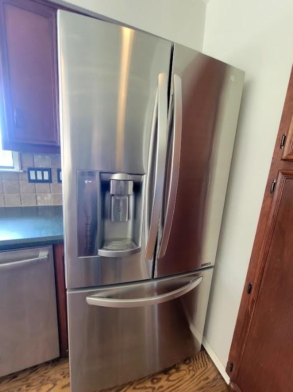 kitchen featuring appliances with stainless steel finishes, dark countertops, and decorative backsplash