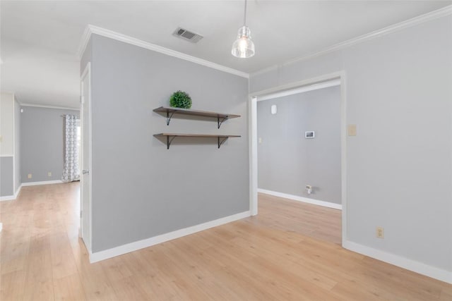 unfurnished room featuring light wood-type flooring, baseboards, visible vents, and ornamental molding