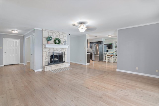 unfurnished living room featuring baseboards, a stone fireplace, light wood-style flooring, and crown molding