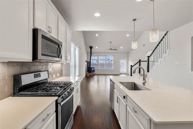 kitchen featuring appliances with stainless steel finishes, dark wood finished floors, a sink, and open floor plan