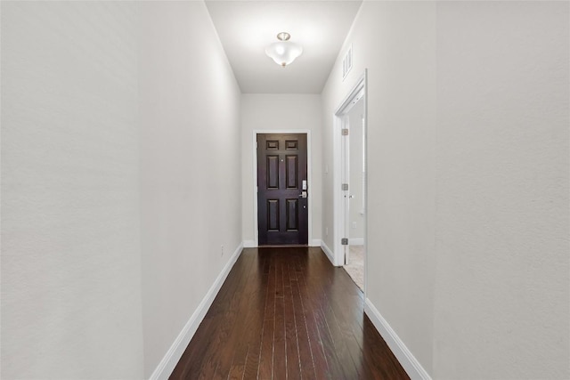 doorway to outside with dark wood-style floors, visible vents, and baseboards