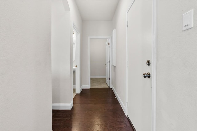 hall featuring baseboards and wood finished floors