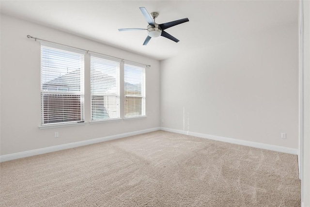 empty room featuring baseboards, ceiling fan, and light colored carpet