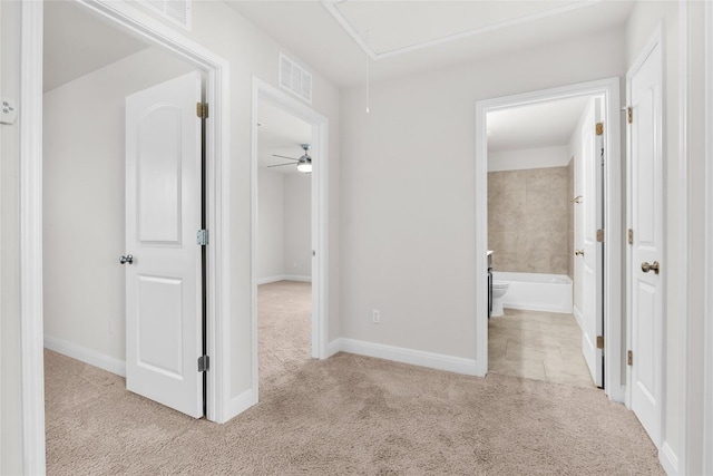 corridor featuring carpet, visible vents, attic access, and baseboards