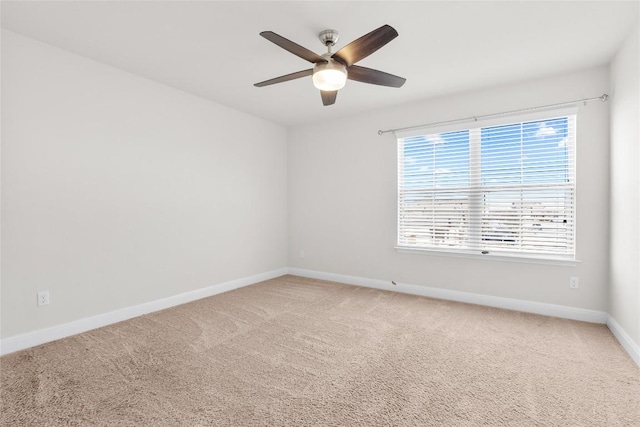 unfurnished room with carpet floors, a ceiling fan, and baseboards