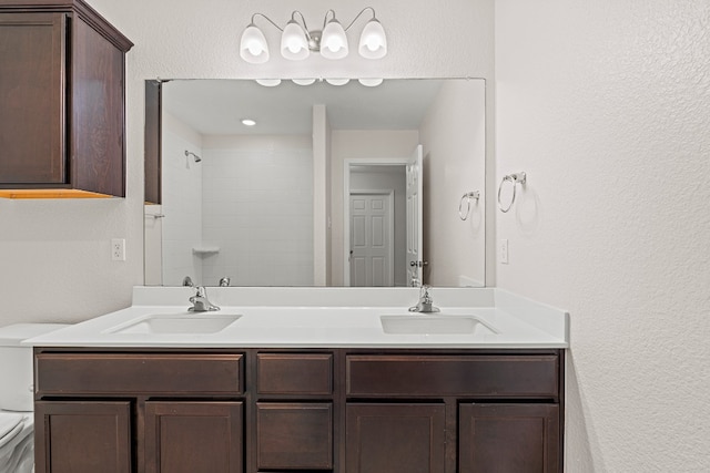 bathroom with a shower, a sink, toilet, and double vanity