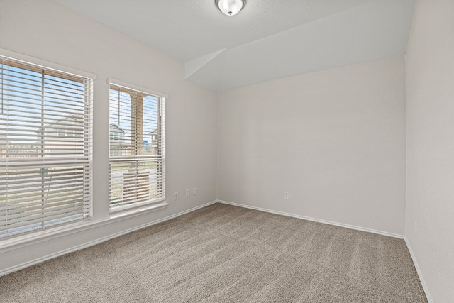 unfurnished room featuring carpet and baseboards