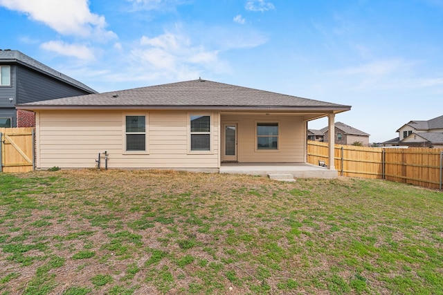 rear view of house with a patio area, a fenced backyard, and a yard