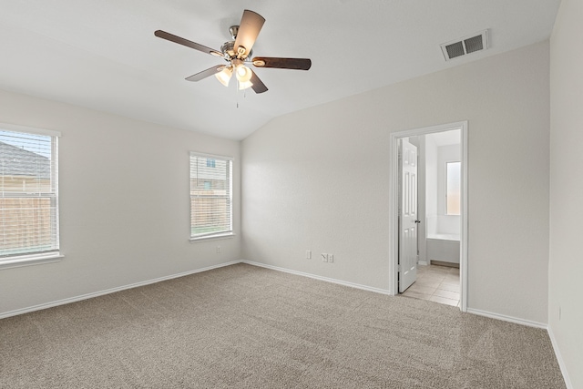 unfurnished room with ceiling fan, light carpet, visible vents, baseboards, and vaulted ceiling