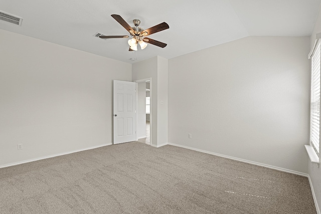 unfurnished room featuring baseboards, visible vents, ceiling fan, vaulted ceiling, and carpet floors