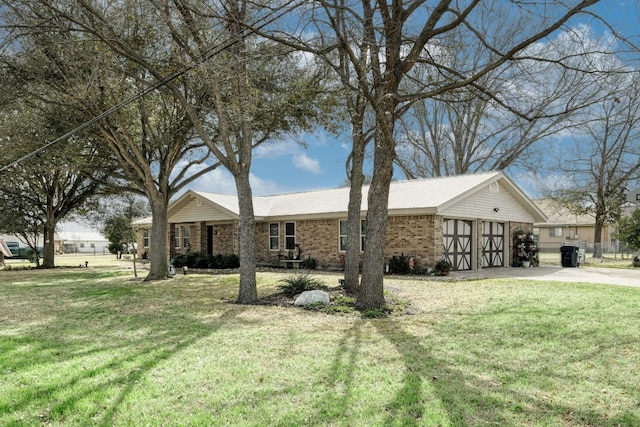 ranch-style home with metal roof, a garage, brick siding, driveway, and a front yard