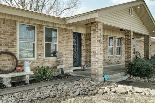 view of exterior entry featuring brick siding