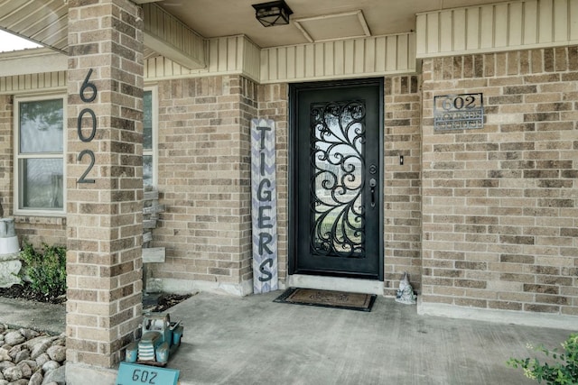 view of exterior entry featuring brick siding