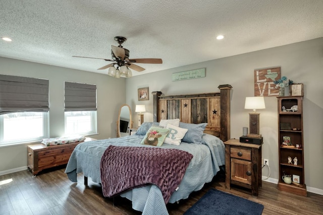 bedroom featuring dark wood-style flooring, ceiling fan, a textured ceiling, and baseboards