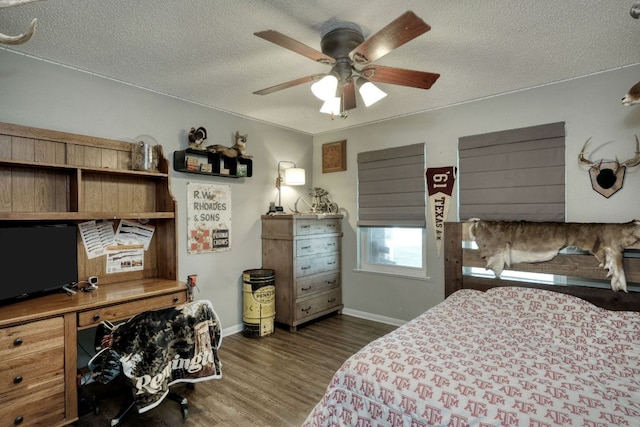 bedroom with ceiling fan, a textured ceiling, baseboards, and wood finished floors