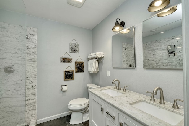 bathroom with a shower, double vanity, a sink, and toilet