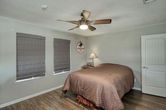 bedroom featuring a ceiling fan, a textured ceiling, baseboards, and wood finished floors