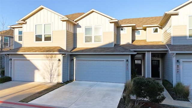 multi unit property with a garage, driveway, and board and batten siding