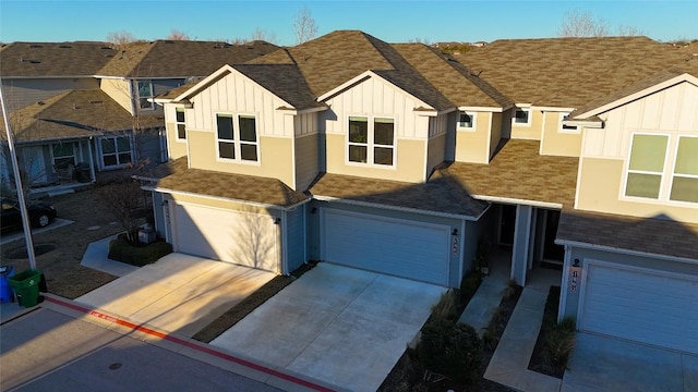 view of front facade with driveway, a shingled roof, board and batten siding, and an attached garage