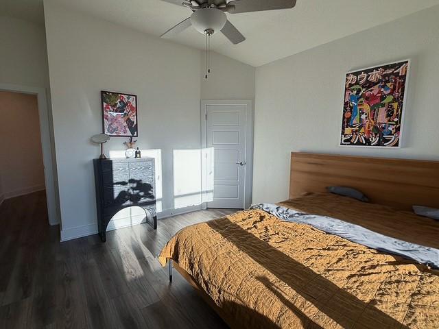 bedroom featuring lofted ceiling, ceiling fan, wood finished floors, and baseboards