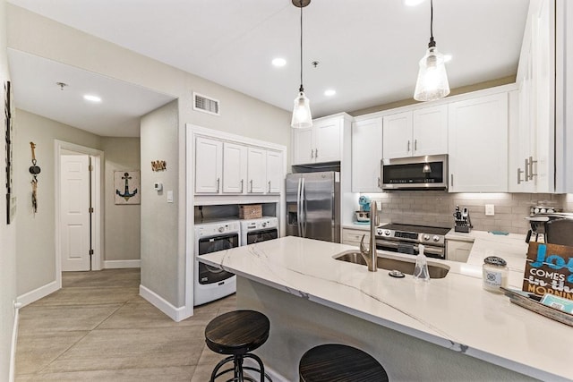 3404 American Dr Unit 3221, Lago Vista, TX 78645 - kitchen with stainless steel appliances, a peninsula, baseboards, decorative backsplash, and white cabinetry