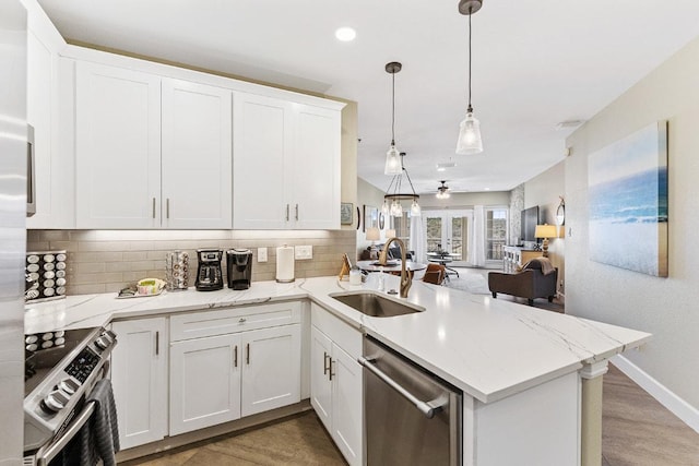 3404 American Dr Unit 3221, Lago Vista, TX 78645 - kitchen featuring appliances with stainless steel finishes, a sink, decorative backsplash, a peninsula, and open floor plan